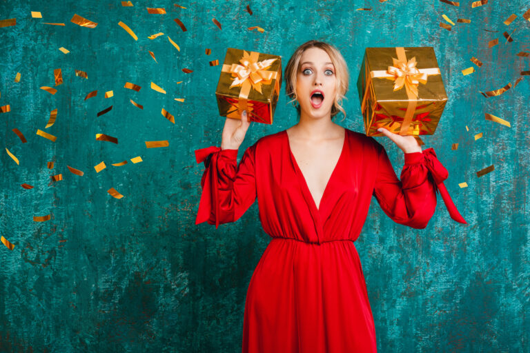 woman in red dress celebrating new year holding presents